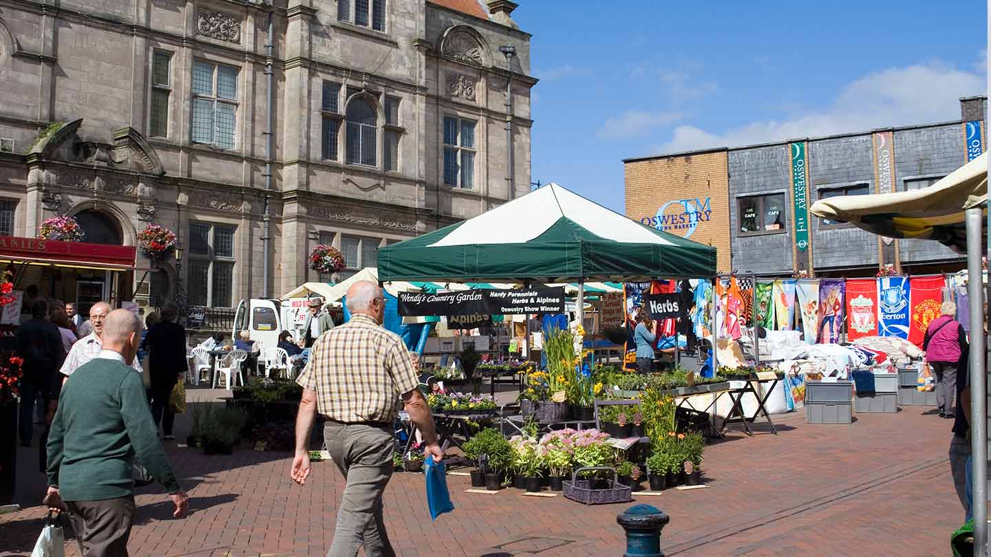 Shoppers walking through Oswestry market