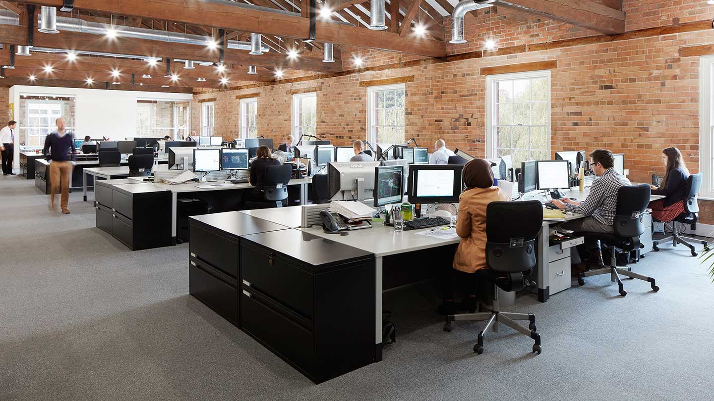 busy open plan office with brick walls and wooden beams